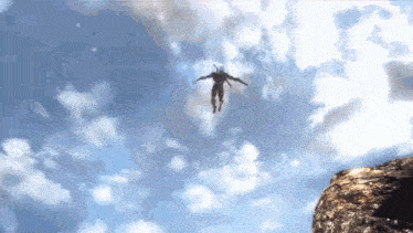 a person is flying through a cloudy sky over a cliff .