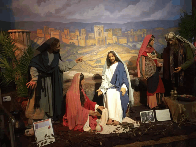 a display of jesus surrounded by people and a sign that says ' jesus and the women ' on it