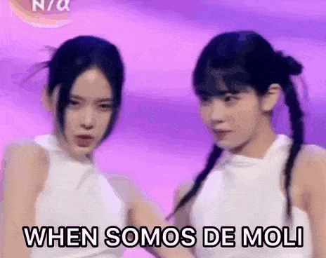 two women are standing next to each other on a purple background and holding hands .