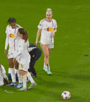 a group of female soccer players are standing on a field