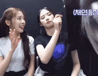 two girls are sitting next to each other and one of them is wearing a t-shirt that says " i love you "
