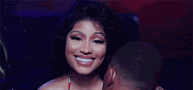 a man is kissing a woman on the cheek while she smiles .