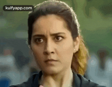 a close up of a woman 's face with a ponytail making a funny face .