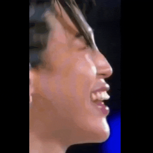a close up of a man 's face with his mouth open and his teeth visible .