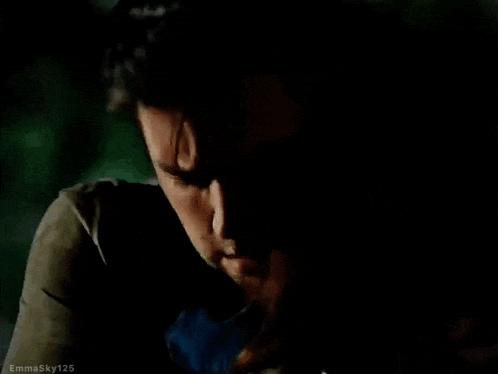 a close up of a man 's face with a woman 's hand on his shoulder .