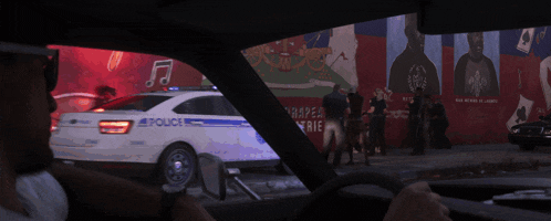 a police car is parked in front of a wall with a picture of a man