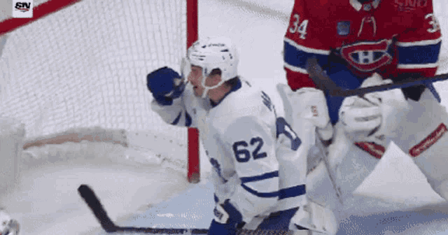 a hockey player with the number 62 on his jersey stands in front of the net