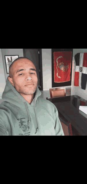 a man taking a selfie with a green hoodie that says us marines on it