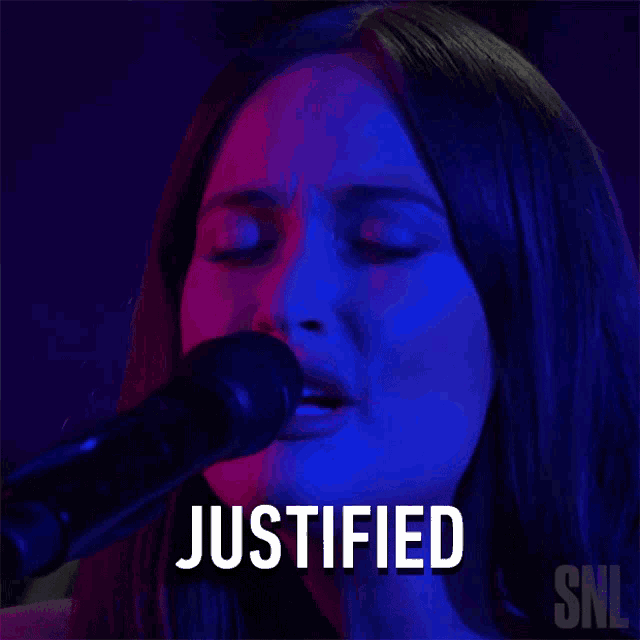 a woman singing into a microphone with the word justified written above her