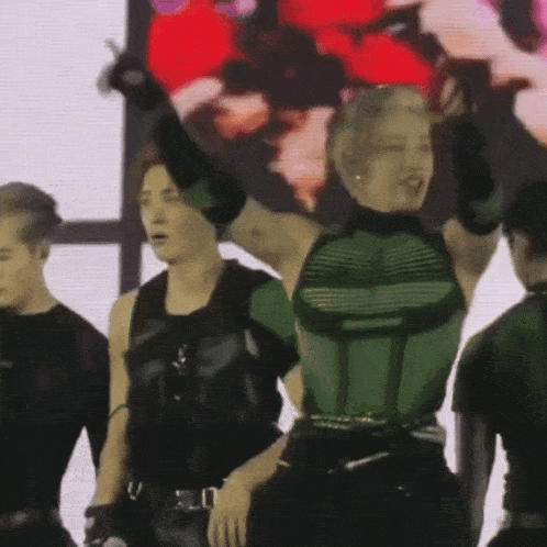 a woman in a green top is standing in front of a crowd