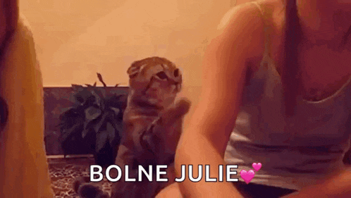 a woman is sitting next to a cat with the words bolne julie in pink letters .