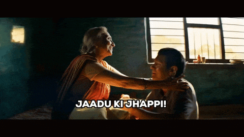 a man and woman are hugging with jaadu ki jhappi written on the bottom