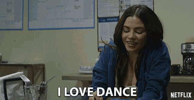 a woman sitting at a table with the words i love dance written on the bottom