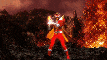 a red superhero with a yellow cape is standing in front of a volcano