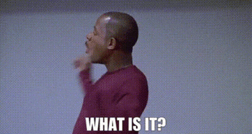 a man in a red sweater is pointing at something and saying `` what is it '' .