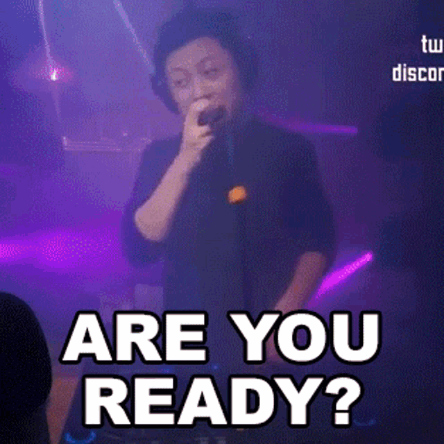 a man singing into a microphone with the words are you ready