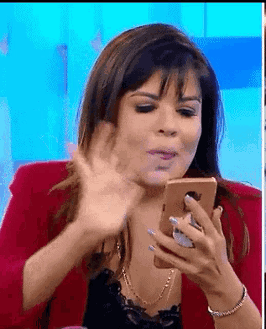 a woman is sitting in a chair holding a cell phone in her hand .