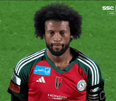 a man with a beard wears a hongoi shirt
