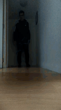 a person in a black adidas jacket is standing on a doorway