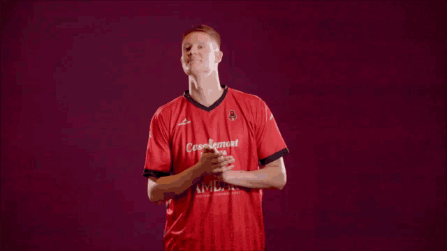 a man wearing a red shirt that says craig amore on it