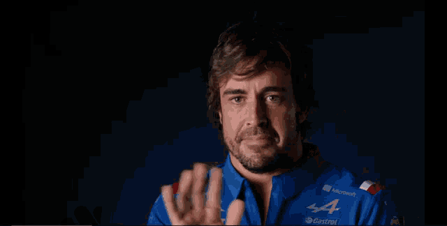 a man wearing a blue castrol shirt talks