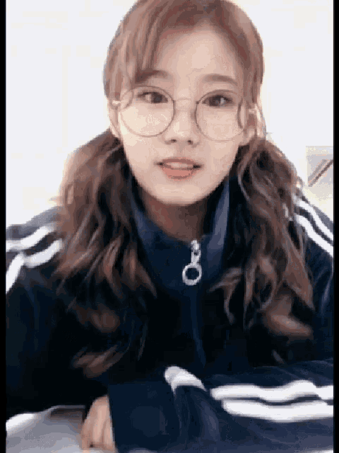 a girl wearing glasses and a blue jacket with white stripes