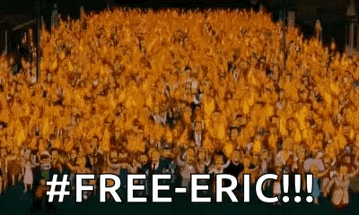 a large group of people are standing in a stadium with the words `` free-eric '' written on the bottom .