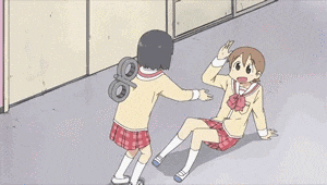 a girl with a wind up toy on her back shakes hands with another girl sitting on the floor