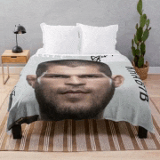 a bed with a blanket with a man 's face on it