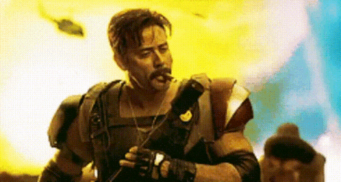 a man in a military uniform is smoking a cigarette while holding a flashlight .