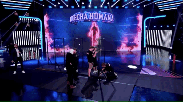 a group of people on a stage in front of a large screen that says " murcha humana "