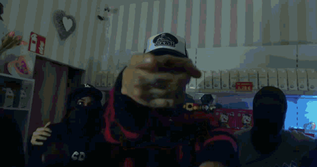 a man wearing a hat that says x-large points at the camera