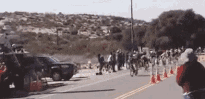 a group of people are riding bikes down a street .