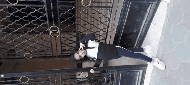 a girl standing in front of a wrought iron gate with a peace sign