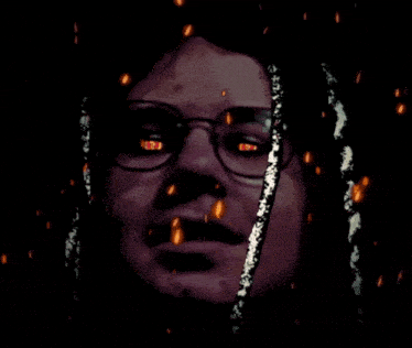 a close up of a person 's face with glasses on