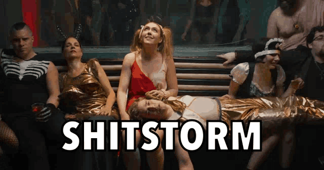a group of people are sitting on a bench and the word shitstorm is on the bottom