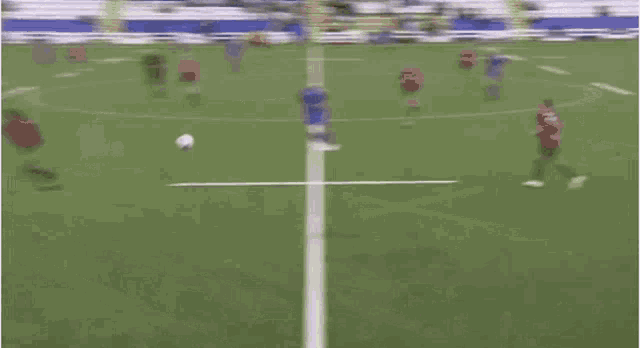 a soccer game is being played on a field with advertisements on the walls .
