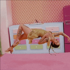 a woman is laying on her back on a pink carpet