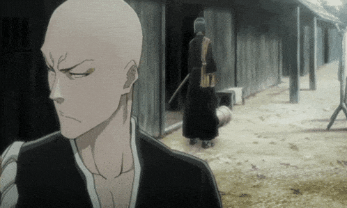 a man with a shaved head is standing in front of a building