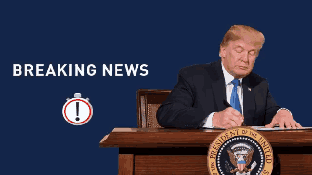 the president of the united states sits at a desk signing a document