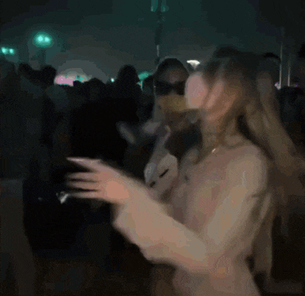 a blurry picture of a woman wearing a mask dancing at a party .