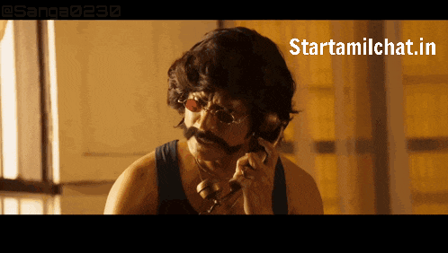 a man with a mustache and glasses is talking on a phone with a starttamilchat.in watermark