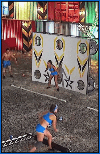 a man and a woman are standing in front of a wall with arrows and stars on it .