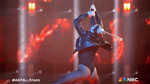 a woman in a black leotard is performing on a stage with a nbc logo in the background
