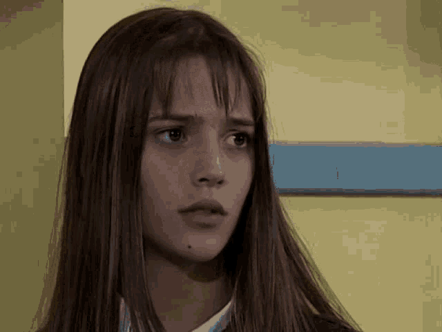 a close up of a woman 's face with long brown hair