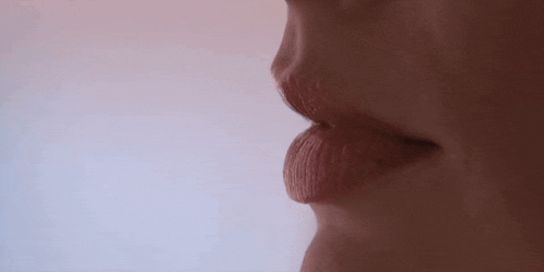 a close up of a woman 's mouth with a blue background