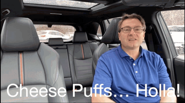 a man sitting in the back seat of a car talking about cheese puffs holla