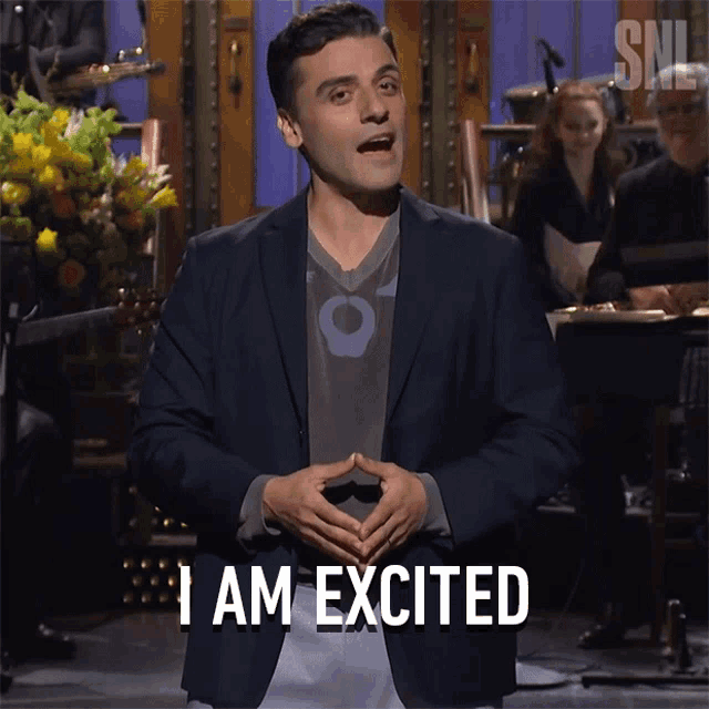 a man in a suit says i am excited in front of a snl logo