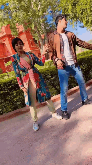 a man and woman are dancing in front of a building