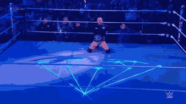 a man in a wrestling ring with a w logo on the bottom